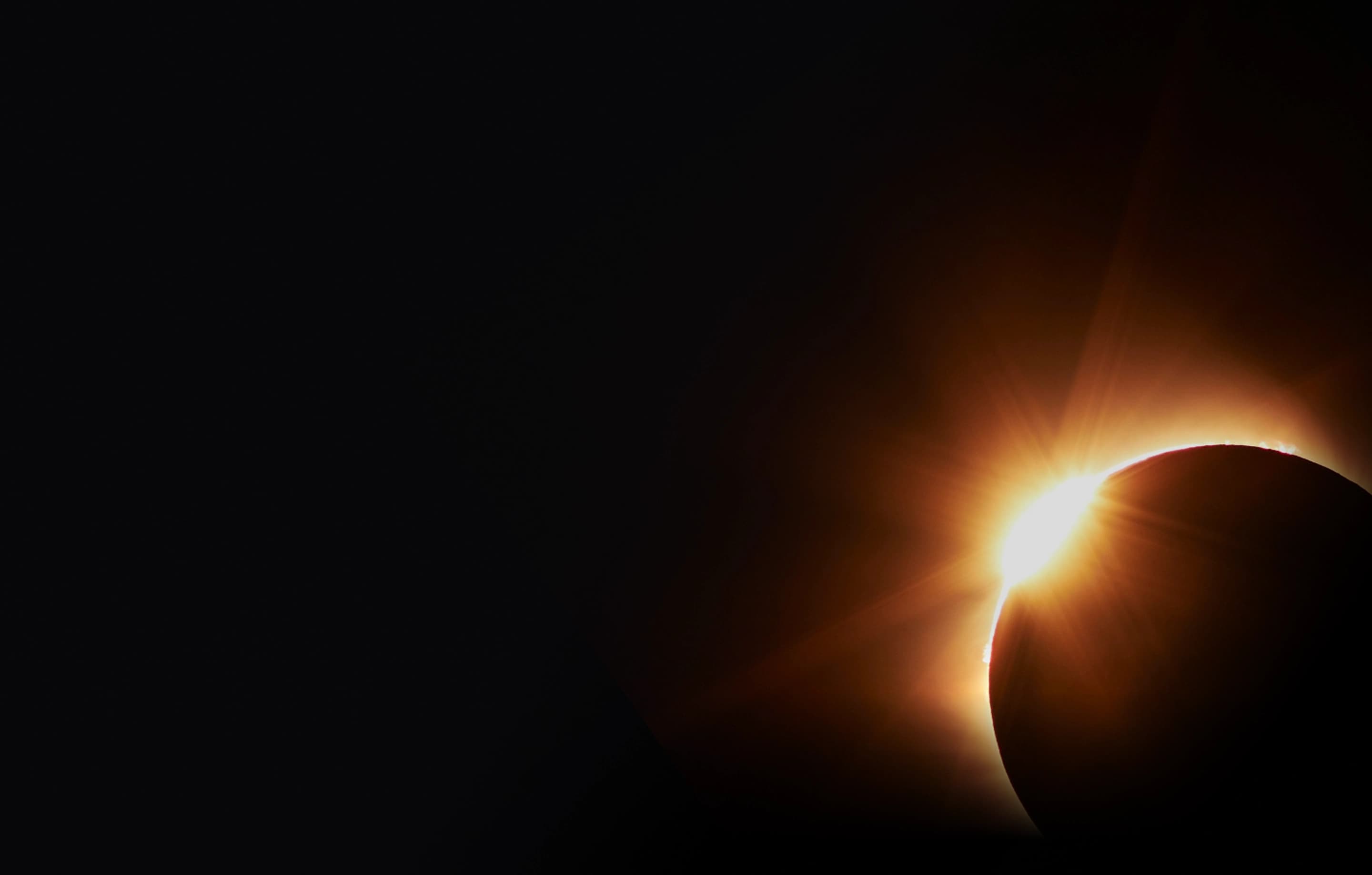 Solar eclipse with the sun forming a bright diamond ring behind the moon.